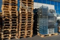 A stack of wooden pallets in an internal warehouse. An outdoor pallet storage area under the roof next to the store. Piles of Euro