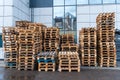 A stack of wooden pallets in an internal warehouse. An outdoor pallet storage area under the roof next to the store. Piles of Euro