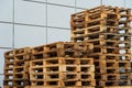 A stack of wooden pallets in an internal warehouse. An outdoor pallet storage area under the roof next to the store. Piles of Euro