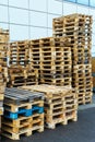 A stack of wooden pallets in an internal warehouse. An outdoor pallet storage area under the roof next to the store. Piles of Euro