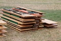 Stack of wooden party tables and benches are lying in the garden after a party Royalty Free Stock Photo