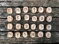 A stack of wooden runes at forest. Wooden runes lie on a old wood background. Runes are cut from wooden blocks. On each