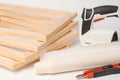 A stack of wooden stretchers on a white background and a tool for stretching canvas on wooden frames