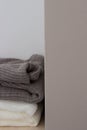 A stack of wool sweaters on the shelf. Grey and white sweater. Warm and cozy. Knitted clothing. winter clothing. Royalty Free Stock Photo