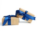 Stack of wrapped boxes in brown kraft paper and tied with silk blue ribbon Royalty Free Stock Photo