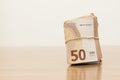 Stack of wrapped and rolled fifty euro banknotes on the table