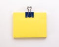 Stack of yellow sheets of paper with blue paper clip on a white Royalty Free Stock Photo
