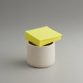 A stack of yellow sticky notes is placed on top of a cylindrical, light beige ceramic Royalty Free Stock Photo