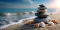 Stack of zen stones balancing on beach with seashells and ocean waves washing ashore Royalty Free Stock Photo