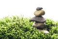 Stack of zen stones in green moss on white background. Natural backdrop for your design