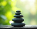 Stack of zen stones pebbles pyramid nature on weathered wooden surface, blur green background. Meditation, tranquility, calm, Royalty Free Stock Photo