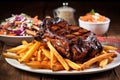 stacked bbq ribs surrounded by crispy fries and colorful coleslaw Royalty Free Stock Photo