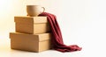 Stacked Beige Gift Boxes with a White Coffee Mug and Red Cloth on Plain White Background Royalty Free Stock Photo