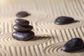 Stacked black stones on Zen garden with sand. Spirituality, relaxation and harmony concept.