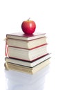 Stacked books with an apple on top isolated on white background