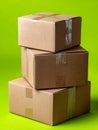 Stacked cardboard boxes on a green background. Royalty Free Stock Photo