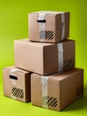 Stacked cardboard boxes with tape on green background. Royalty Free Stock Photo