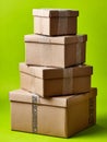 Stacked cardboard boxes on a vibrant green background Royalty Free Stock Photo