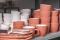 Stacked ceramic bowls, pots, dishes and mugs, clay handmade products after baking in kilns in the potter`s studio Royalty Free Stock Photo