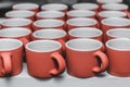 Stacked ceramic red mugs, clay handmade products after baking in kilns in the potter`s studio Royalty Free Stock Photo