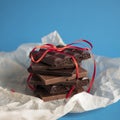 Stacked chocolate pieces wrapped up with a ribbon as a sweet romantic gift. Love or desire concept