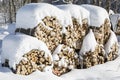 Stacked chopped firewood covered by snow in winter Royalty Free Stock Photo
