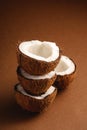 Stacked coconut fruits on brown plain background, abstract food tropical concept