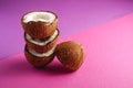 Stacked coconut fruits on violet and purple plain background, abstract food tropical concept