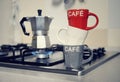 Stacked coffee cup and vintage coffeepot on kitchen stove