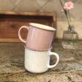 Stacked Coffee Mugs Pink and White on Kitchen Counter