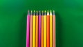 Stacked colored pencils. Isolated on green background Royalty Free Stock Photo