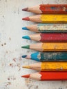 Stacked colored pencils on a worn wooden surface. Royalty Free Stock Photo