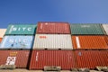 Stacked colorful shipping containers against blue sky