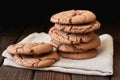 Stacked cookies on brown napkin and on wooden table