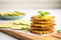 stacked dehydrated zucchini pizza crusts beside zucchinis