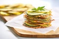 stacked dehydrated zucchini pizza crusts beside zucchinis