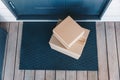 Stacked Delivery Packages on a Front Doorstep Mat Surrounded by a Cozy Home Ambience. Royalty Free Stock Photo