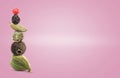 Stacked different aromatic spices on pink background, space for text