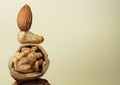 Stacked different nuts on beige gradient background, space for text