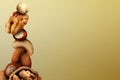 Stacked different nuts on golden gradient background, space for text