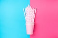 Stacked Drinking Paper Cups with Striped Straws on Duo Tone Mint Blue Pink Background. Flat Lay. Birthday Party Celebration Kids Royalty Free Stock Photo