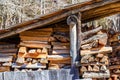 Stacked firewood under an open-air shelter with a shingle roof Royalty Free Stock Photo