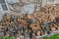 Stacked firewood wood lumber timber stack logs and trunks pile by a historic cottage cottage