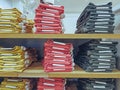 Stacked Folded Colorful Jeans on Shelf at Clothing Store