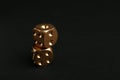 Stacked gold dices on black background
