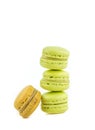 Stacked green cake macaron isolated near one brown macaron on white background, maccarone sweet dessert