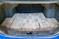 Stacked grey bricks loaded in the trunk of a car