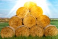 Stacked hay bales after harvest at the edge of the field with sun rays. Dry straw pressed into individual straw bales Royalty Free Stock Photo