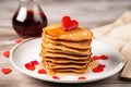 stacked heart-shaped pancakes with syrup for valentines day breakfast