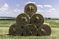 Stacked like a pyramid, round yellow bales of straw in sunny weather. Royalty Free Stock Photo